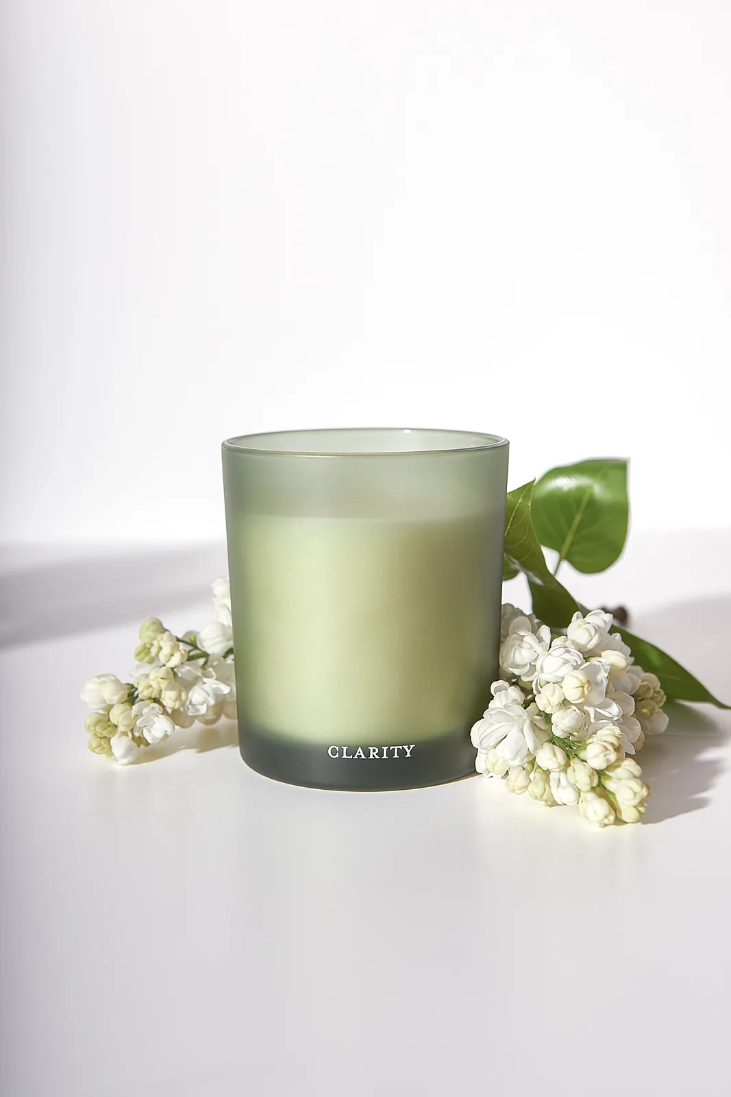 Commercial product photography by a UK photographer — candle styled with lilac florals, Clarity Home Fragrance