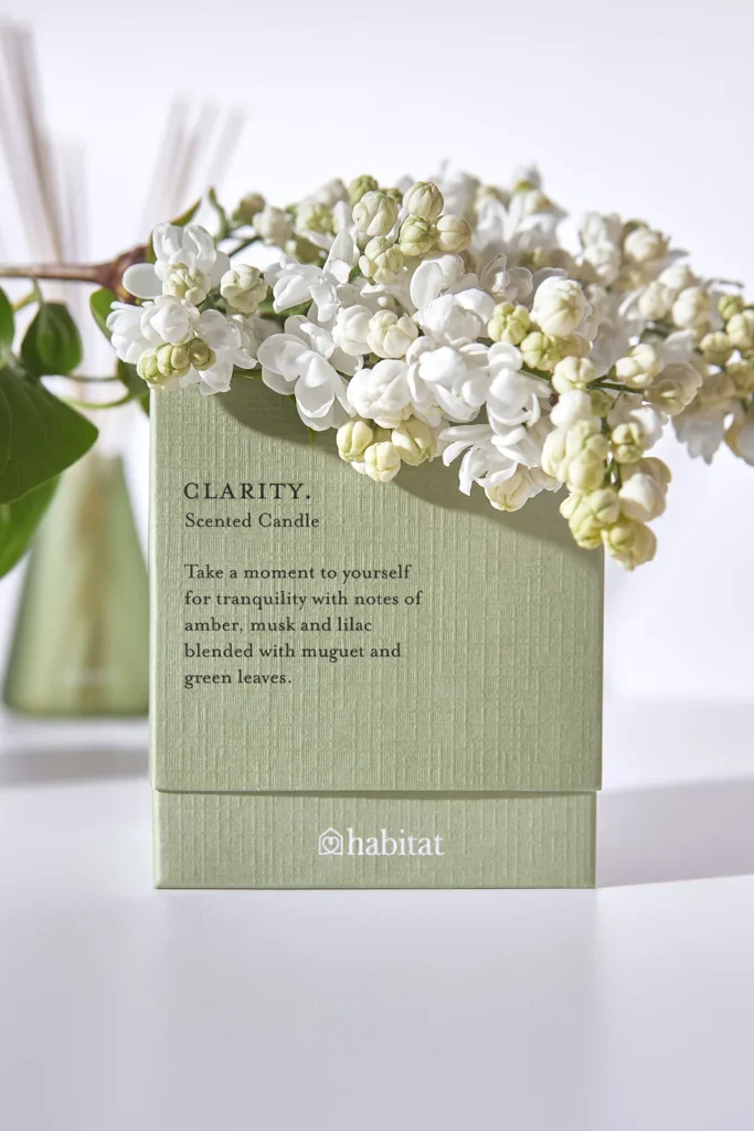Lifestyle product photography — home fragrance gift packaging styled with flowers