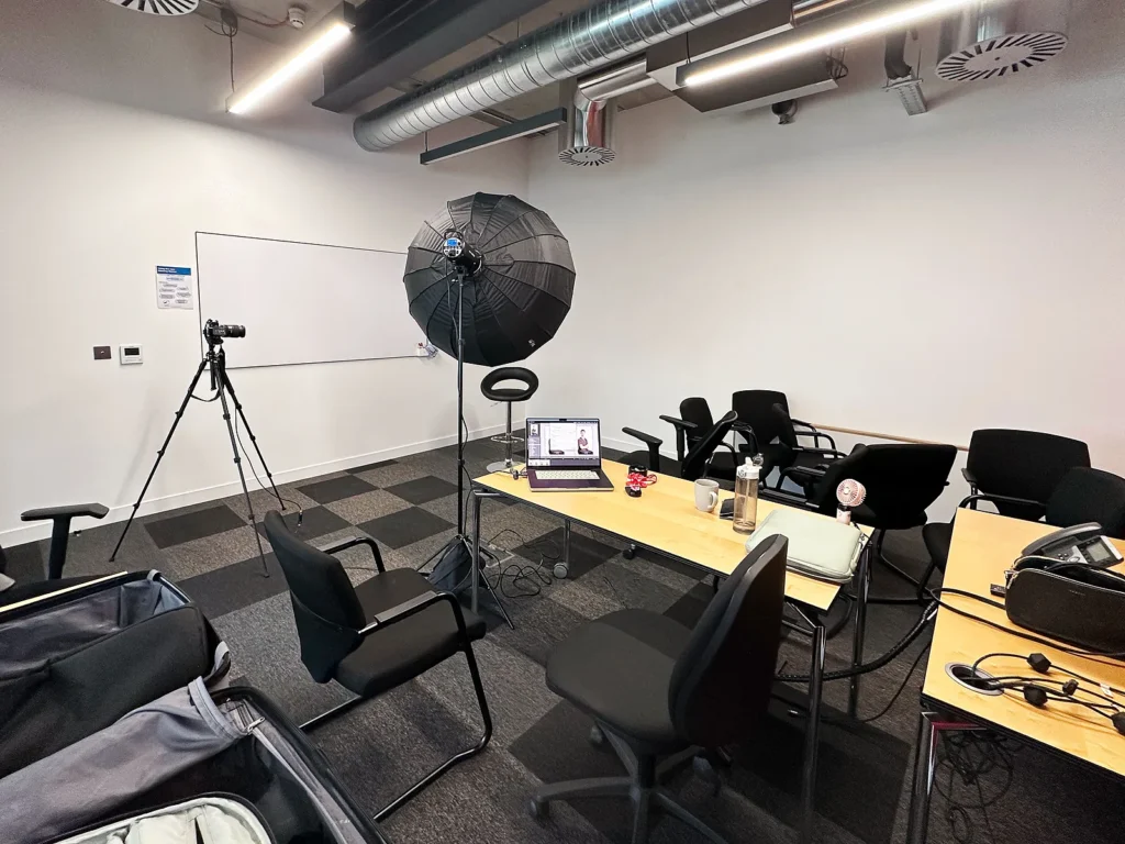 Portable studio setup for on-location headshot photography, featuring softbox lighting and camera on tripod at a client's office.