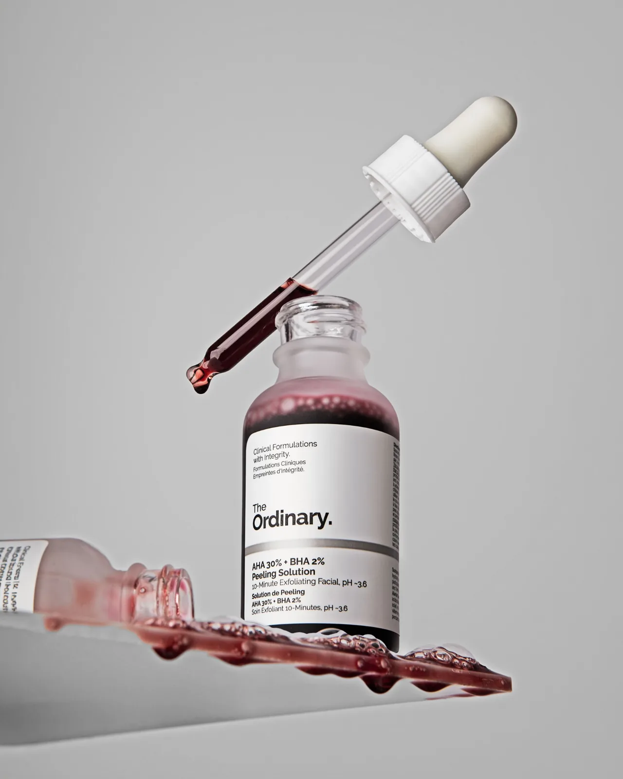 Personal care product photography of a face serum ina frosted glass bottle with glass dropper.