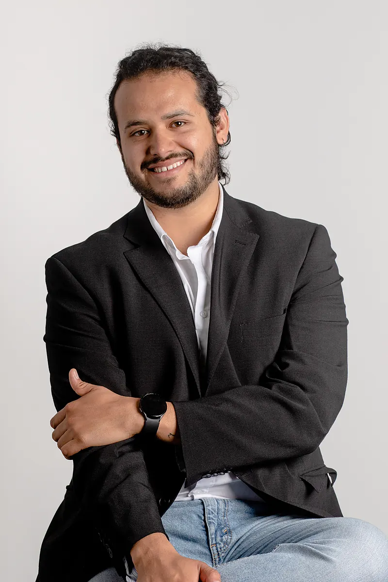 Professional corporate headshot photography in Oxfordshire — a smiling businessman in a dark blazer, arms crossed, against a clean studio backdrop.