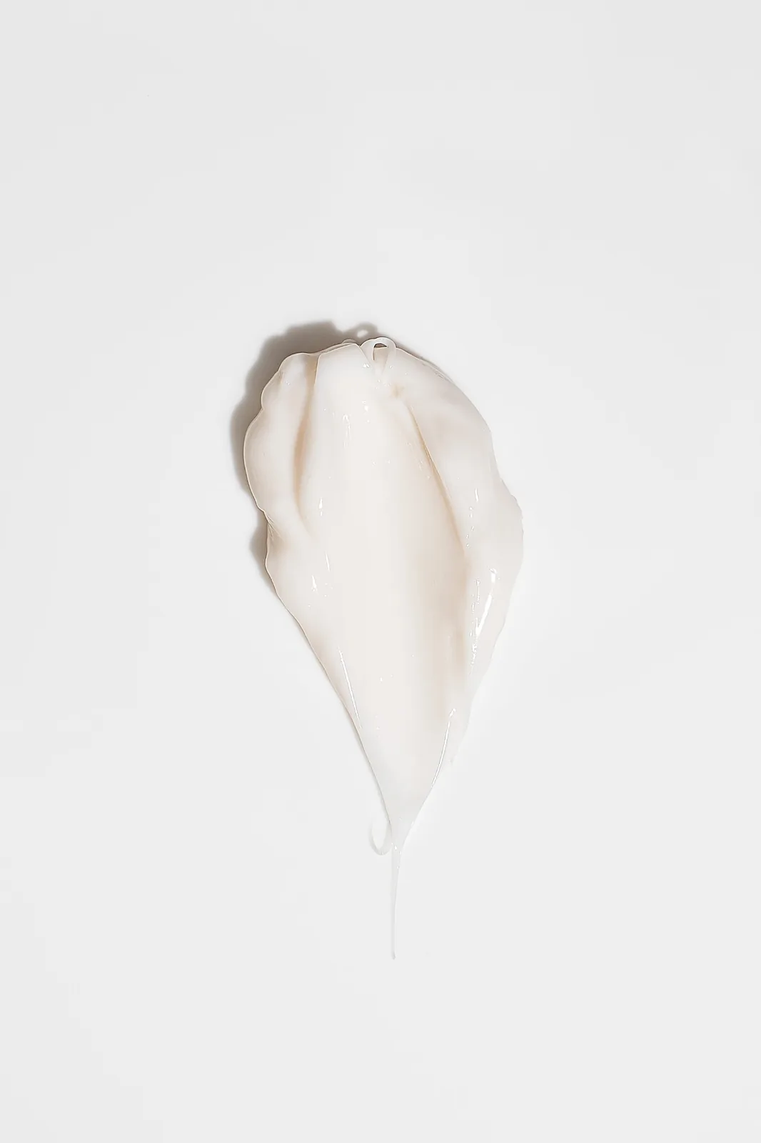 Ecommerce product photography UK – glossy white cream texture swatch smeared on a clean white background.