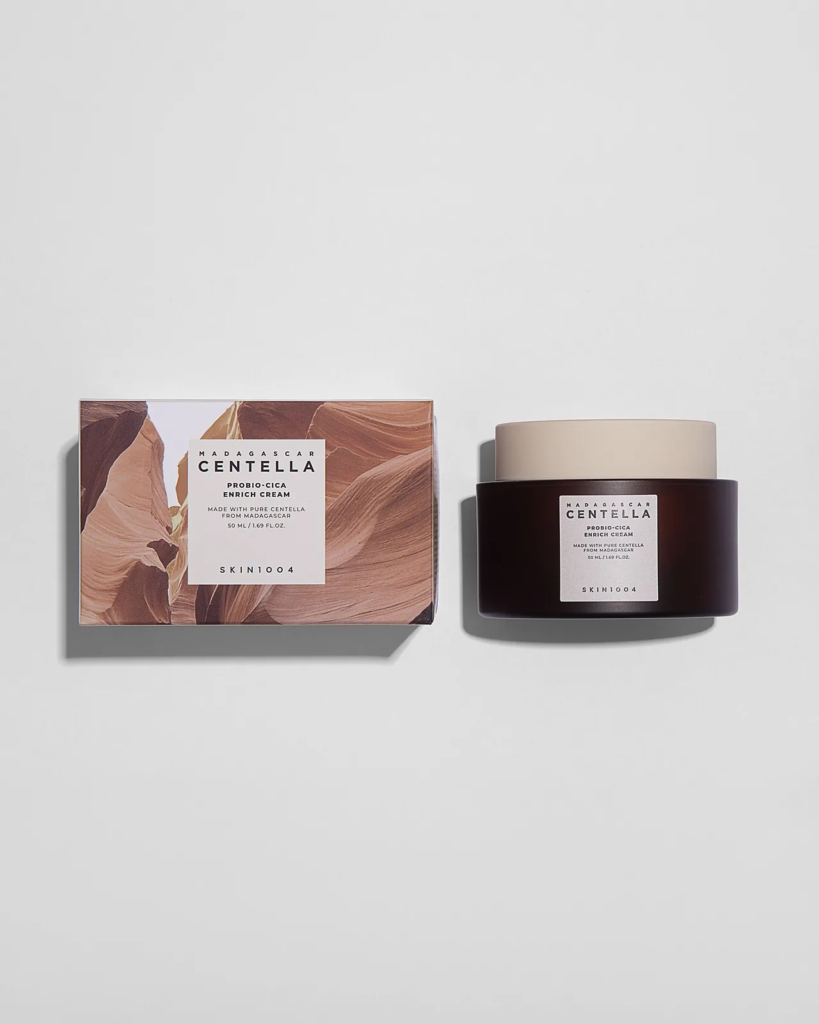Flat lay ecommerce product photography of a skincare cream jar beside its printed box on a pale grey background.
